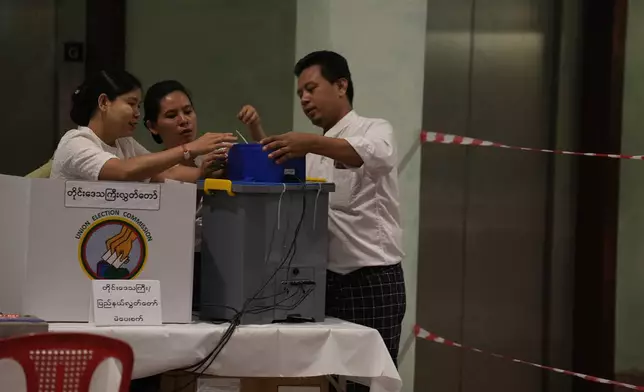 Election volunteers prepare to open a polling station, Sunday, Dec. 28, 2025, in Yangon, Myanmar. (AP Photo/Thein Zaw)