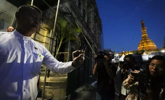 A voter shows off her finger marked with ink indicating she voted as she leaves a polling station, Sunday, Dec. 28, 2025, in Yangon, Myanmar. (AP Photo/Thein Zaw)