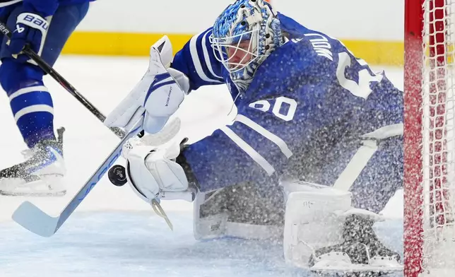 Toronto Maple Leafs goaltender Joseph Woll (60) makes a save against the New Jersey Devils during the first period of an NHL hockey game in Toronto, Tuesday Dec. 30, 2025. (Frank Gunn/The Canadian Press via AP)