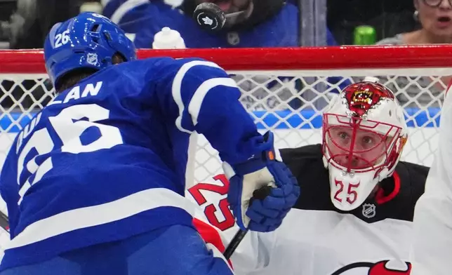 New Jersey Devils goaltender Jacob Markstrom (25) watches the puck as Toronto Maple Leafs' Jacob Quillan skates towards the net during the first period of an NHL hockey game in Toronto, Tuesday Dec. 30, 2025. (Frank Gunn/The Canadian Press via AP)