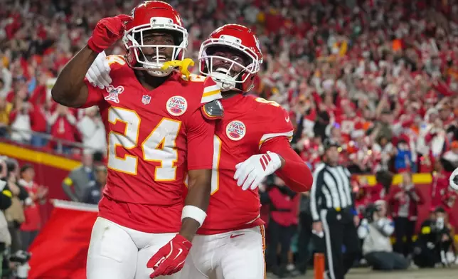 Kansas City Chiefs running back Brashard Smith (24) celebrates with wide receiver Juju Smith-Schuster after scoring a touchdown against the Denver Broncos during the first half of an NFL football game Thursday, Dec. 25, 2025, in Kansas City, Mo. (AP Photo/Ed Zurga)