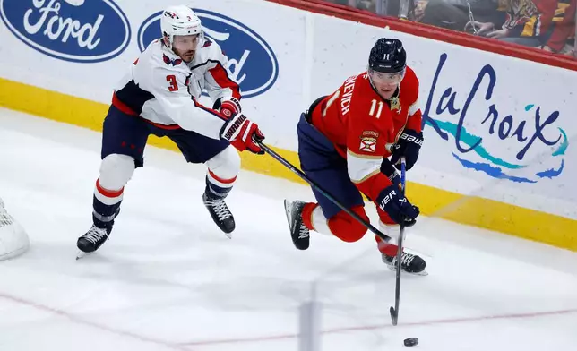 Washington Capitals defenseman Matt Roy (3) and Florida Panthers right wing Mackie Samoskevich (11) chase the puck during the second period of an NHL hockey game, Monday, Dec. 29, 2025, in Sunrise, Fla. (AP Photo/Rhona Wise)