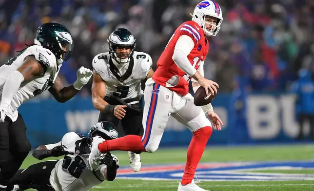 Buffalo Bills' Josh Allen (17) tries to ge away from Philadelphia Eagles' Jalyx Hunt (58), Jalen Carter (98) and Nolan Smith (3) during the second half of an NFL football game, Sunday, Dec. 28, 2025, in Buffalo, N.Y. (AP Photo/Adrian Kraus)