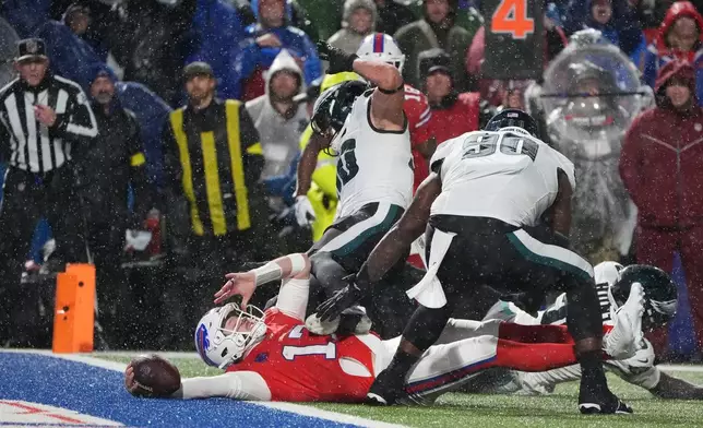 Buffalo Bills' Josh Allen (17) is tackled short of a touchdown by Philadelphia Eagles' Jaelan Phillips (50) and Jordan Davis (90) during the second half of an NFL football game, Sunday, Dec. 28, 2025, in Buffalo, N.Y. (AP Photo/Gene J. Puskar)