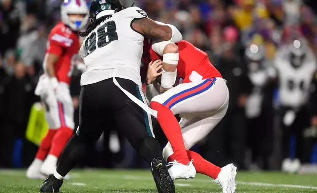 Philadelphia Eagles' Jalen Carter, left, sacks Buffalo Bills' Josh Allen during the first half of an NFL football game, Sunday, Dec. 28, 2025, in Buffalo, N.Y. (AP Photo/Adrian Kraus)