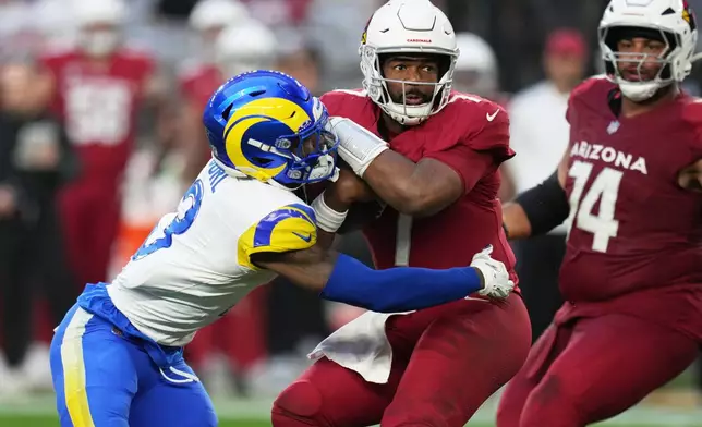 Los Angeles Rams safety Kam Curl, left, sacks Arizona Cardinals quarterback Jacoby Brissett, center, in the second half of an NFL football game Sunday, Dec. 7, 2025, in Glendale, Ariz. (AP Photo/Rick Scuteri)