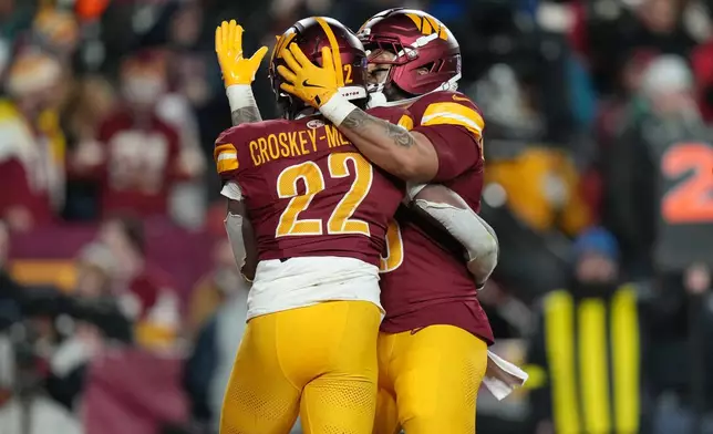 Washington Commanders running back Jacory Croskey-Merritt (22) celebrates after his touchdown against the Philadelphia Eagles during the first half of an NFL football game, Saturday, Dec. 20, 2025, in Landover, Md. (AP Photo/Stephanie Scarbrough)