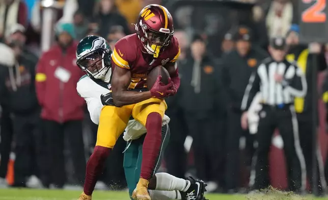 Washington Commanders wide receiver Terry McLaurin is tackled by Philadelphia Eagles cornerback Adoree' Jackson during the first half of an NFL football game, Saturday, Dec. 20, 2025, in Landover, Md. (AP Photo/Stephanie Scarbrough)