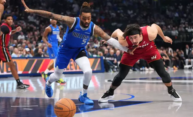 Dallas Mavericks guard D'Angelo Russell (5) and Miami Heat forward Jaime Jaquez Jr. chase after a loose ball during the first half of an NBA basketball game Wednesday, Dec. 3, 2025, in Dallas. (AP Photo/Julio Cortez)