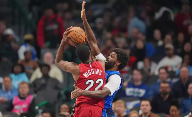 Miami Heat forward Andrew Wiggins (22) goes up for a basket against Dallas Mavericks forward Naji Marshall during the first half of an NBA basketball game Wednesday, Dec. 3, 2025, in Dallas. (AP Photo/Julio Cortez)
