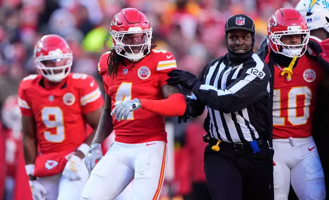 Kansas City Chiefs wide receiver Rashee Rice (4) is held back by an official during the second half of an NFL football game against the Los Angeles Chargers Sunday, Dec. 14, 2025, in Kansas City, Mo. (AP Photo/Charlie Riedel)