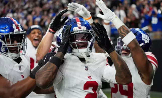 New York Giants cornerback Deonte Banks (2) celebrates his touchdown with teammates during the second half of an NFL football game against the Las Vegas Raiders Sunday, Dec. 28, 2025, in Las Vegas. (AP Photo/John Locher)