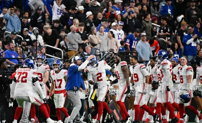 New York Giants cornerback Deonte Banks (2) is congratulated by interim head coach Mike Kafka after scoring a touchdown during the second half of an NFL football game against the Las Vegas Raiders Sunday, Dec. 28, 2025, in Las Vegas. (AP Photo/David Becker)
