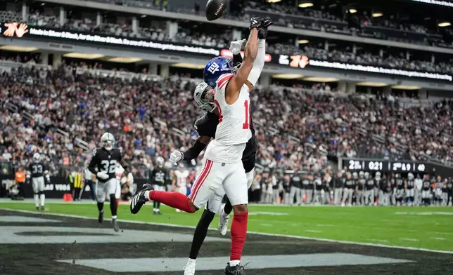 Las Vegas Raiders cornerback Darien Porter (26) breaks up a pass intended for New York Giants wide receiver Darius Slayton (18) during the first half of an NFL football game Sunday, Dec. 28, 2025, in Las Vegas. (AP Photo/John Locher)