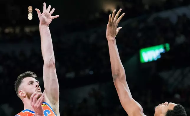 Oklahoma Thunder center Isaiah Hartenstein (55) shoots against San Antonio Spurs forward Victor Wembanyama (1) during the first half of an NBA basketball game in San Antonio, Tuesday, Dec. 23, 2025. (AP Photo/Rodolfo Gonzalez)