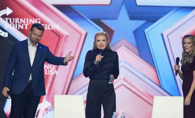 Erika Kirk, center, speaks as Jack Posobiec, left, and Megyn Kelly look on during Turning Point USA's AmericaFest 2025, Friday, Dec. 19, 2025, in Phoenix. (AP Photo/Ross D. Franklin)