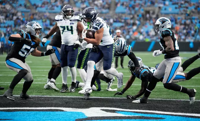 Seattle Seahawks running back Zach Charbonnet scores against the Carolina Panthers during the second half of an NFL football game, Sunday, Dec. 28, 2025, in Charlotte, N.C. (AP Photo/Jacob Kupferman)