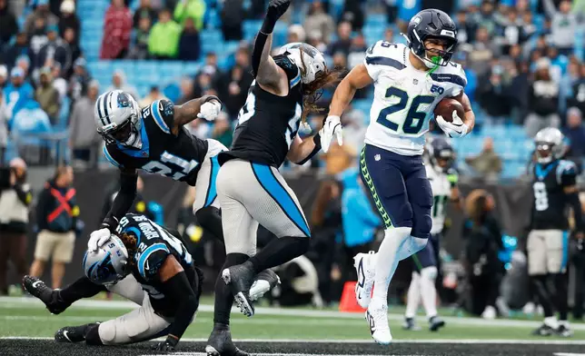 Seattle Seahawks running back Zach Charbonnet scores against the Carolina Panthers during the second half of an NFL football game, Sunday, Dec. 28, 2025, in Charlotte, N.C. (AP Photo/Rusty Jones)