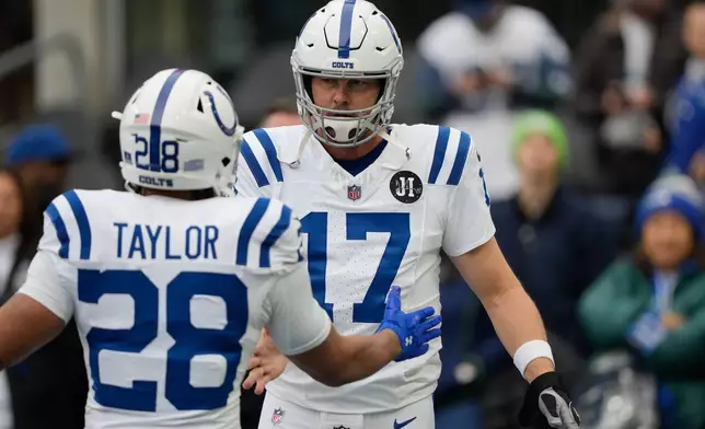 Indianapolis Colts quarterback Philip Rivers (17) greets running back Jonathan Taylor (28) before an NFL football game against the Seattle Seahawks, Sunday, Dec. 14, 2025, in Seattle. (AP Photo/Stephen Brashear)