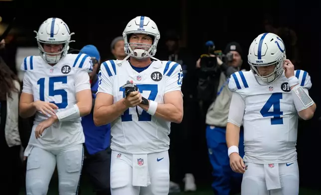 Indianapolis Colts quarterback Philip Rivers (17) walks on to the field with teammates Riley Leonard (15) and Brett Rypien (4) before an NFL football game against the Seattle Seahawks, Sunday, Dec. 14, 2025, in Seattle. (AP Photo/Stephen Brashear)
