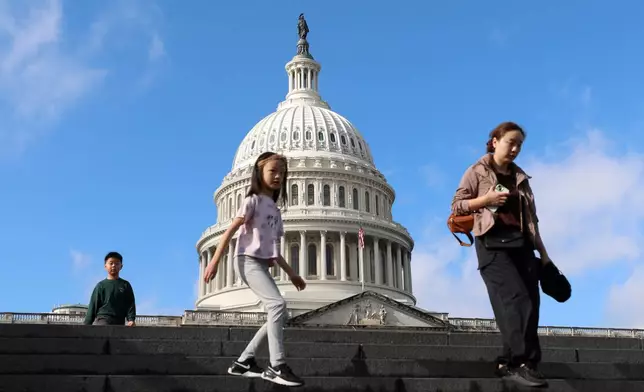 Visitors walk the steps in front of the the U.S. Capitol, Wednesday, Nov. 26, 2025, in Washington. (AP Photo/Rahmat Gul)