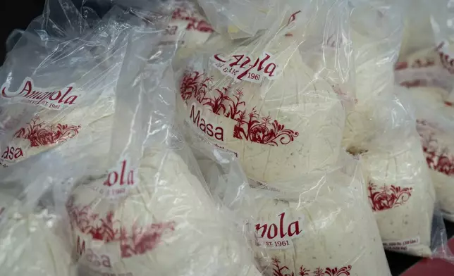 Bags of masa, a dough used to make tamales, are stacked on a counter at Amapola Market in Downey, Calif., Tuesday, Dec. 23, 2025. (AP Photo/Jae C. Hong)