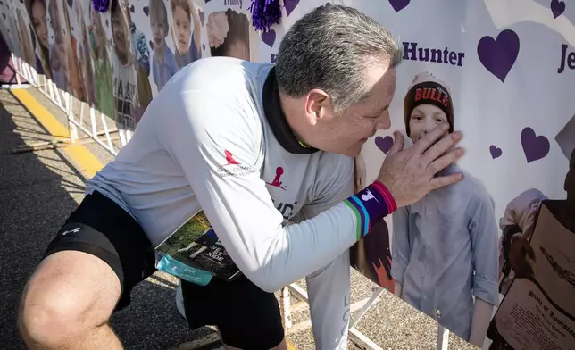 John, the father of a St. Jude patient, pauses with a photo of his son, Hunter. He carries Hunter’s memory with him each St. Jude Memphis Marathon Weekend and is an active fundraiser through the St. Jude Heroes program.