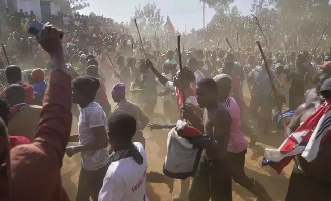 A crowd of spectators dances and sings after bull Shakahola won bullfighting match, in Kakamega, Kenya, Saturday, Nov. 29, 2025. (AP Photo/Brian Inganga)