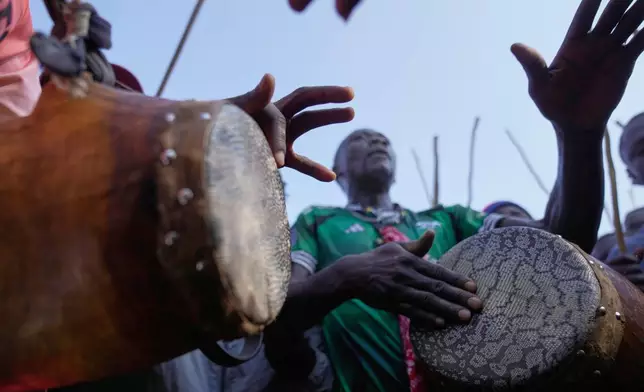 A crowd of spectators dances and sings "Isukuti," a traditional dance accompanied by a set of three drums, after bull Shakahola won bullfighting match, in Kakamega, Kenya, Saturday, Nov. 29, 2025. (AP Photo/Brian Inganga)