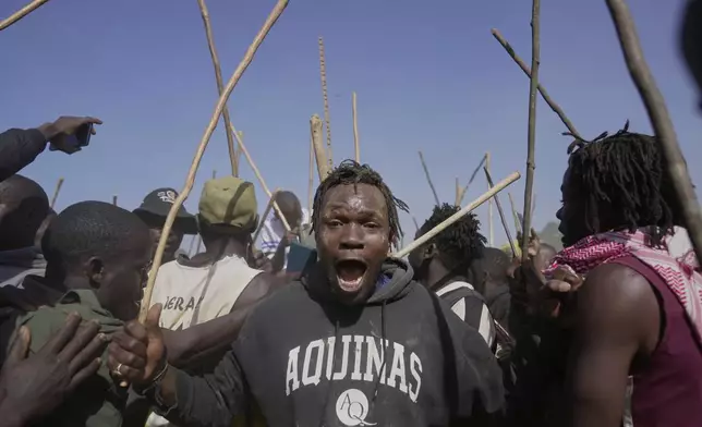 A spectator dances and sings after bull Shakahola won bullfighting match, in Kakamega, Kenya, Saturday, Nov. 29, 2025. (AP Photo/Brian Inganga)