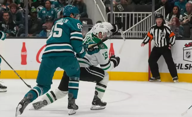 San Jose Sharks defenseman Shakir Mukhamadullin, left, is called for a penalty against Dallas Stars center Colin Blackwell (15) during the second period of an NHL hockey game in San Jose, Calif., Thursday, Dec. 18, 2025. (AP Photo/Jeff Chiu)