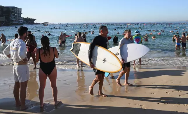 FILE - Surfers and swimmers leave the water after a tribute following last Sunday's shooting at Bondi Beach, in Sydney, Friday, Dec. 19, 2025. (AP Photo/Steve Markham,File)