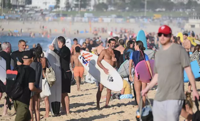 FILE - Surfers and swimmers leave the water after a tribute following last Sunday's shooting at Bondi Beach, in Sydney, Friday, Dec. 19, 2025. (AP Photo/Steve Markham,File)