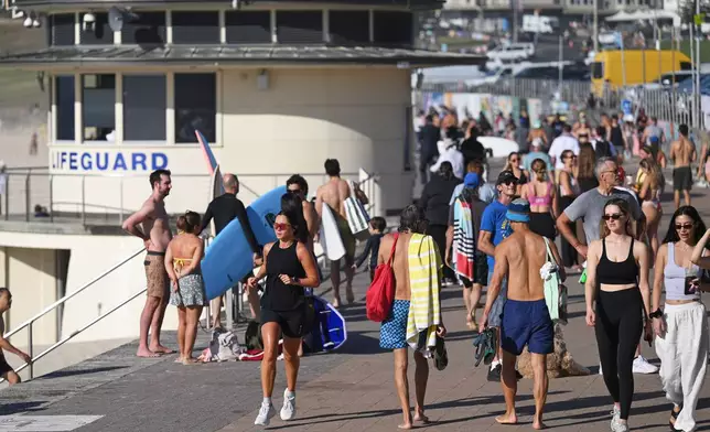 FILE - Surfers and swimmers walk along the promenade at Bondi Beach in Sydney, Friday, Dec. 19, 2025. (AP Photo/Steve Markham, File)