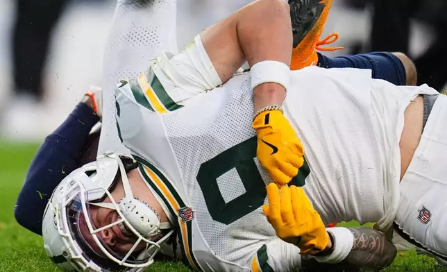 Green Bay Packers' Christian Watson reacts after an injury during the second half of an NFL football game against the Denver Broncos Sunday, Dec. 14, 2025, in Denver. (AP Photo/Jack Dempsey)