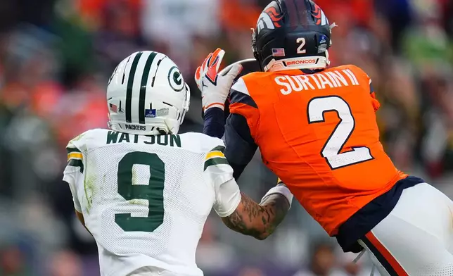 Denver Broncos' Pat Surtain II intercepts a pass in front of Green Bay Packers' Christian Watson during the second half of an NFL football game Sunday, Dec. 14, 2025, in Denver. (AP Photo/Jack Dempsey)