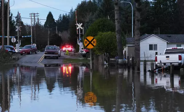 Floodwaters cover a road after heavy rains led to historic flooding in the region Saturday, Dec. 13, 2025, in Burlington, Wash. (AP Photo/Lindsey Wasson)