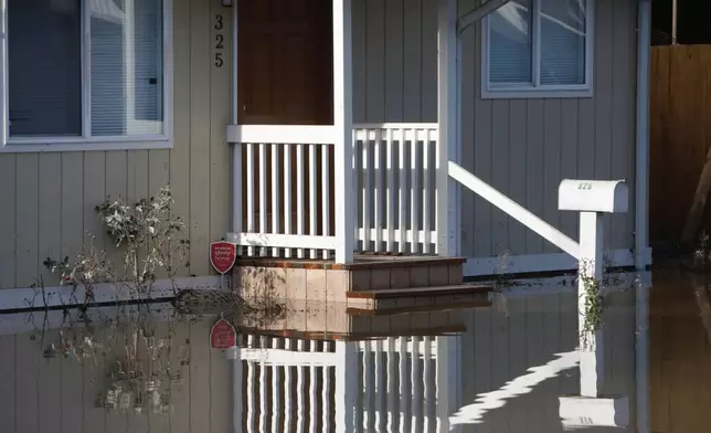 Floodwater surrounds a home in Burlington, Wash., Saturday, Dec. 13, 2025. (AP Photo/Manuel Valdes)