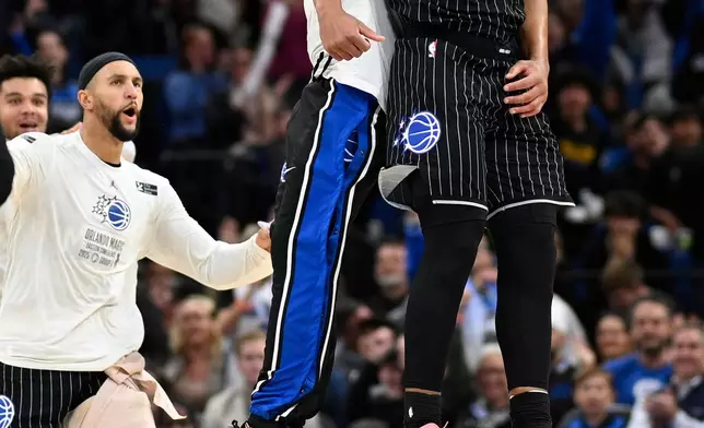 Orlando Magic guard Desmond Bane, right, celebrates with guard Jase Richardson, center, and guard Jalen Suggs, left, after scoring a 3-pointer during the second half of an NBA Cup basketball game against the Miami Heat, Tuesday, Dec. 9, 2025, in Orlando, Fla. (AP Photo/Phelan M. Ebenhack)