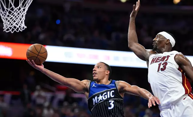 Orlando Magic guard Desmond Bane (3) goes up to shoot as Miami Heat center Bam Adebayo (13) defends during the second half of an NBA Cup basketball game, Tuesday, Dec. 9, 2025, in Orlando, Fla. (AP Photo/Phelan M. Ebenhack)