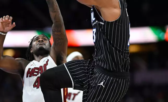 Orlando Magic guard Desmond Bane (3) goes up to shoot in front of Miami Heat guard Davion Mitchell, left, during the second half of an NBA Cup basketball game, Tuesday, Dec. 9, 2025, in Orlando, Fla. (AP Photo/Phelan M. Ebenhack)