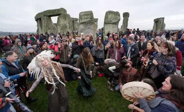 People take part in the winter solstice celebrations during sunrise at the Stonehenge prehistoric monument on Salisbury Plain in Wiltshire, England, Sunday, Dec. 21, 2025. (Andrew Matthew/PA via AP)