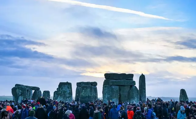 People celebrate the Winter Solstice sunrise celebrations at Stonehenge, a world-famous prehistoric monument on Salisbury Plain, England, Sunday, Dec. 21, 2025.(AP Photo/Anthony Upton)