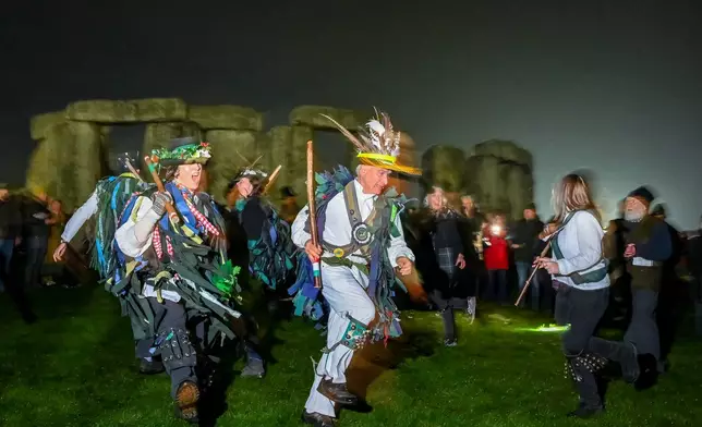 People celebrate the Winter Solstice sunrise celebrations at Stonehenge, a world-famous prehistoric monument on Salisbury Plain, England, Sunday, Dec. 21, 2025.(AP Photo/Anthony Upton)