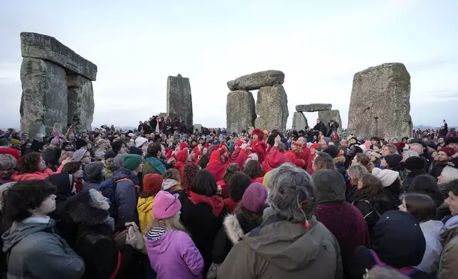 People take part in the winter solstice celebrations during sunrise at the Stonehenge prehistoric monument on Salisbury Plain in Wiltshire, England, Sunday, Dec. 21, 2025. (Andrew Matthew/PA via AP)