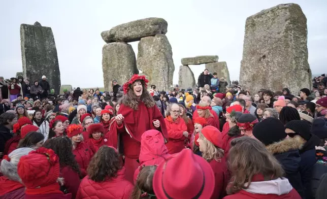 People take part in the winter solstice celebrations during sunrise at the Stonehenge prehistoric monument on Salisbury Plain in Wiltshire, England, Sunday, Dec. 21, 2025. (Andrew Matthew/PA via AP)