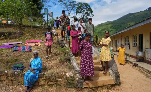 Tea plantation workers evacuated after Cyclone Ditwah led to floods and landslides spend time out of a safety center in Galamuduna Estate in Dolosbage, Sri Lanka, Friday, Dec.12, 2025. (AP Photo/Eranga Jayawardena)
