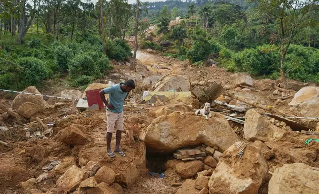 Marasamy Suresh, a tea plantation worker, looks at where the body of a boy is buried in the rubble of a plantation workers' living quarters after Cyclone Ditwah led to floods and landslides at Craighead Estate in Nawalapitiya, Sri Lanka, Friday, Dec.12, 2025. (AP Photo/Eranga Jayawardena)