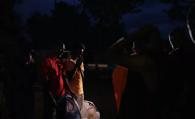 Displaced tea plantation workers from Cyclone Ditwah that led to floods and landslides express gratitude after receiving relief items from local residents at a safety center at Craighead Estate in Nawalapitiya, Sri Lanka, Thursday, Dec, 11, 2025. (AP Photo/Eranga Jayawardena)