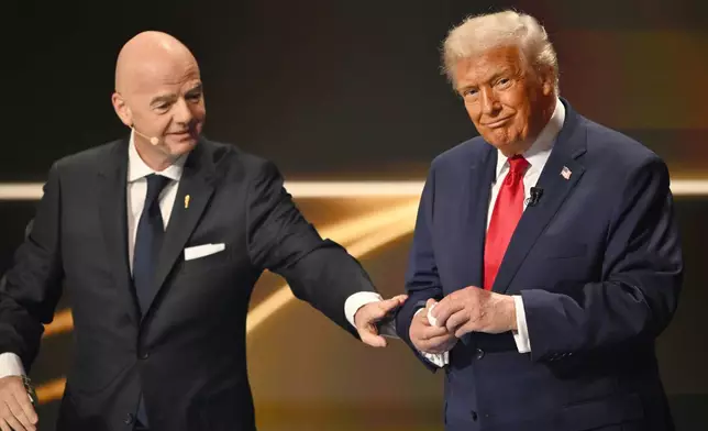 FIFA President Gianni Infantino pauses President Donald Trump during the draw for the 2026 soccer World Cup at the Kennedy Center in Washington, Friday, Dec. 5, 2025. (Mandel Ngan/Pool Photo via AP)